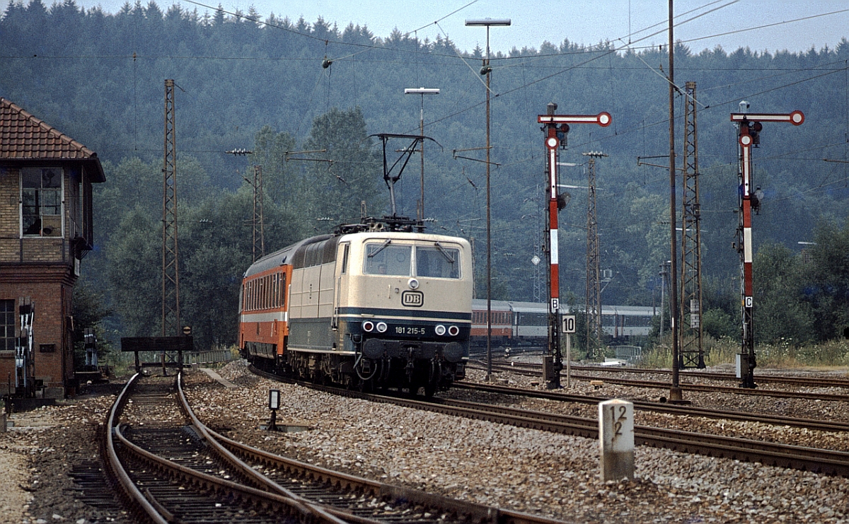 Mit dem  Mozart  Paris-Wien legt sich die heute TEE-farbene 181 215 in Wilferdingen-Singen, Strecke Karlsruhe - Stuttgart, in die Kurve (August 1979).