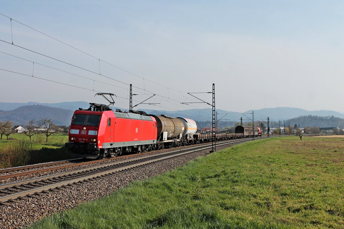 Mit dem Übergabezug EZ 52050 (Freiburg (Brsg) Gbf - Offenburg Gbf) fuhr am Nachmittag des 27.03.2020 die 185 115-3 bei Kollmarsreute vor der Kulisse des Schwarzwaldes über die Rheintalbahn in Richtung Emmendingen.