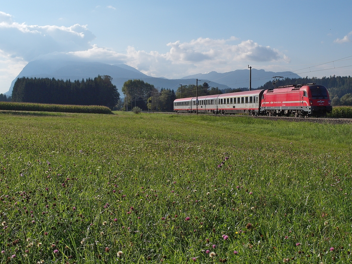 Mit dem wolkenverhangenen Hausberg von Villach, dem 2.166 m hohen Dobratsch im Hintergrund zieht am 17.09.2014 bei Faak am See SZ 541 018 den in Villach Hbf gestarteten EC 213 nach Zagreb.