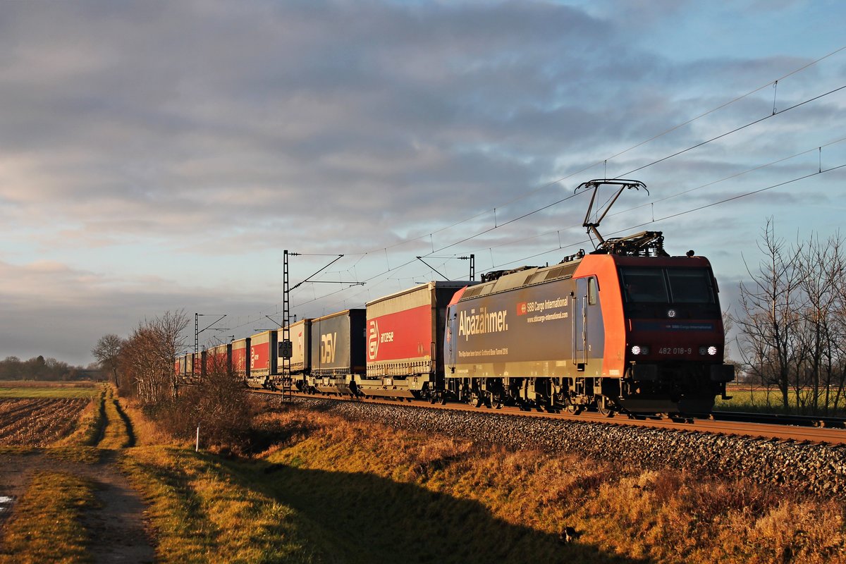 Mit einem  arcese/DSV -KLV nach Lübeck fuhr am Morgen des 23.12.2017 die Re 482 018-9  Alpäzähmer  nördlich von Müllheim (Baden) bei Hügelheim durchs Rheintal in Richtung Freiburg (Breisgau).