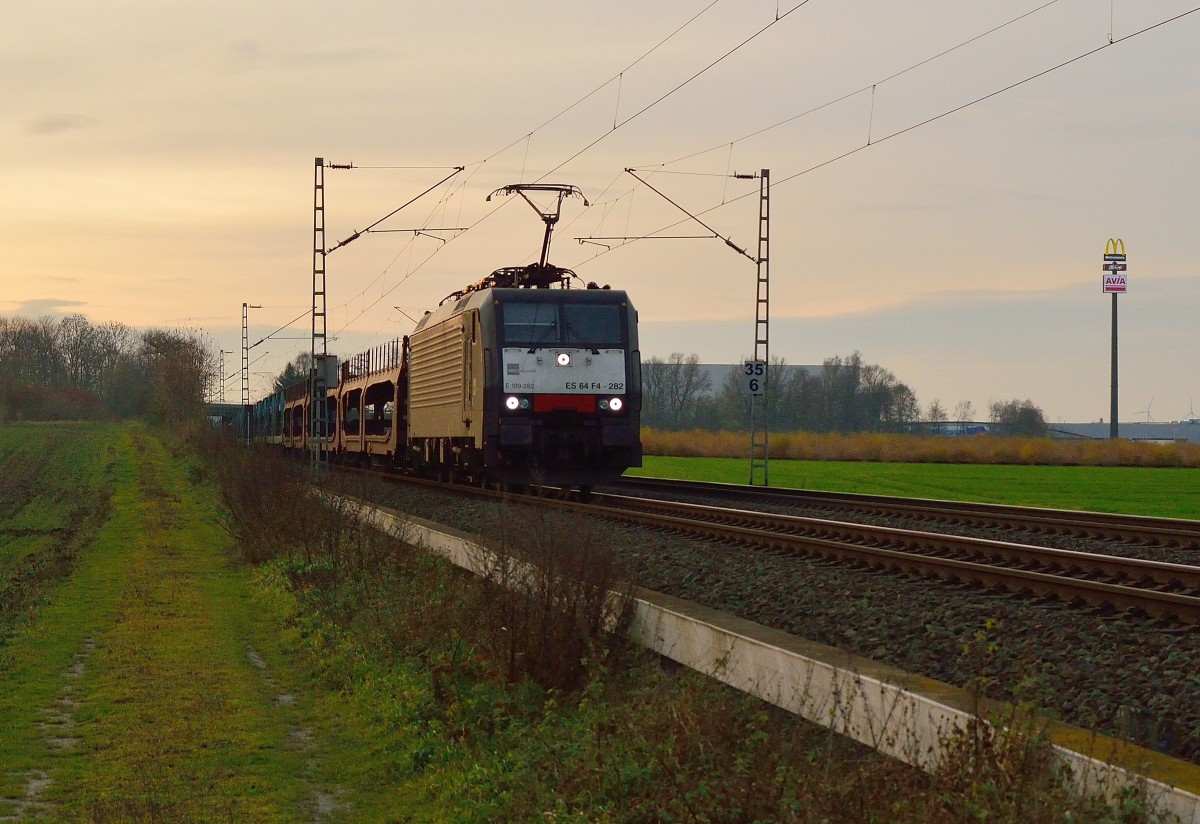 Mit einem Autozug am Haken ist die E189 282 von MRCE zwischen Jüchen und Gubberath unterwegs. P.S. Trotz anderslautender Gerüchte ist dieses Bild nicht vom Lokverleiher, noch vom Junkfoodvertreiber und auch nicht vom Verband notleidender Mineralölvertreiber gesponsort ;-D 8.12.2013