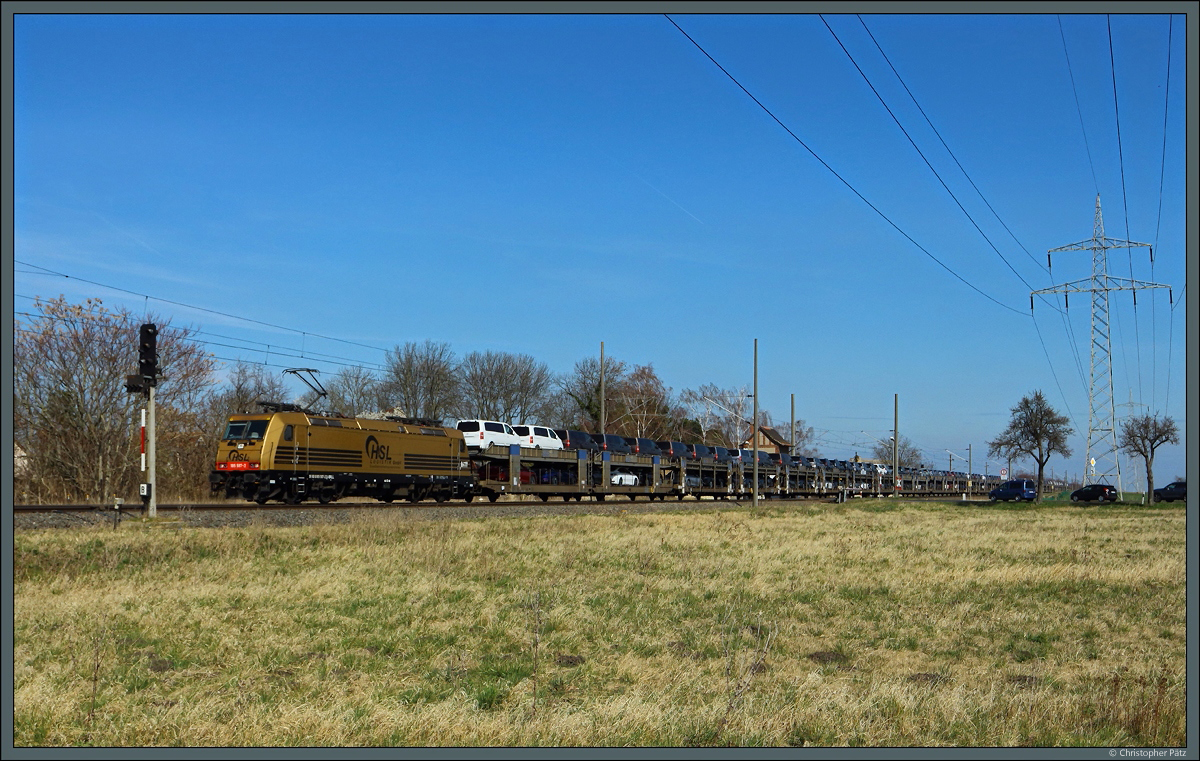 Mit einem Autozug rollt 185 597-2  Goldie  der HSL am 26.03.2022 durch Braschwitz.