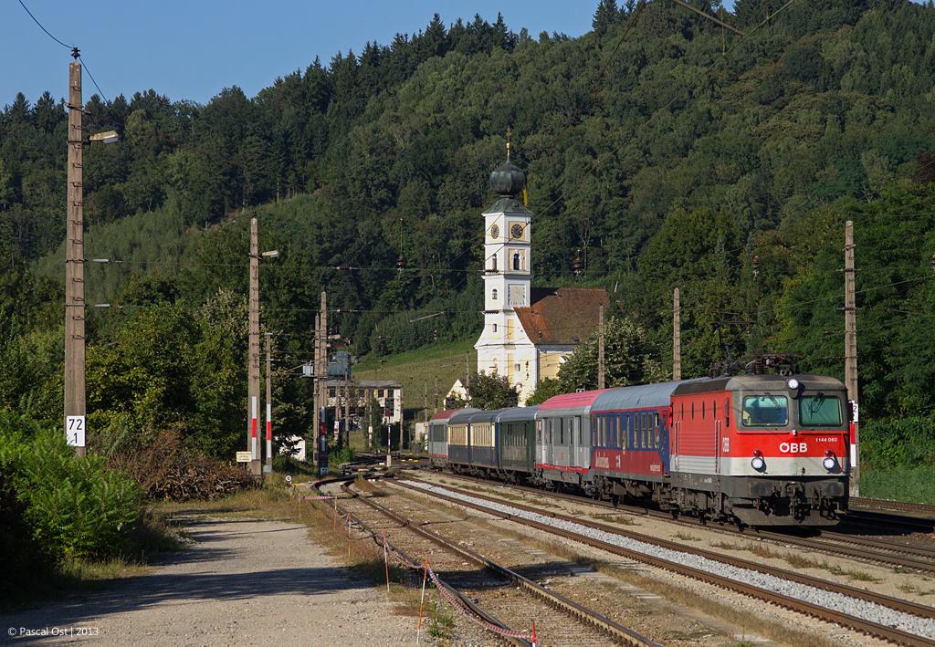 Mit einem bunt gemischten Zug durchfhrt die mit LED-Scheinwerfern ausgestattete 1144 060 am 5. September 2013 den Bahnhof Wernstein in Richtung Schrding.
