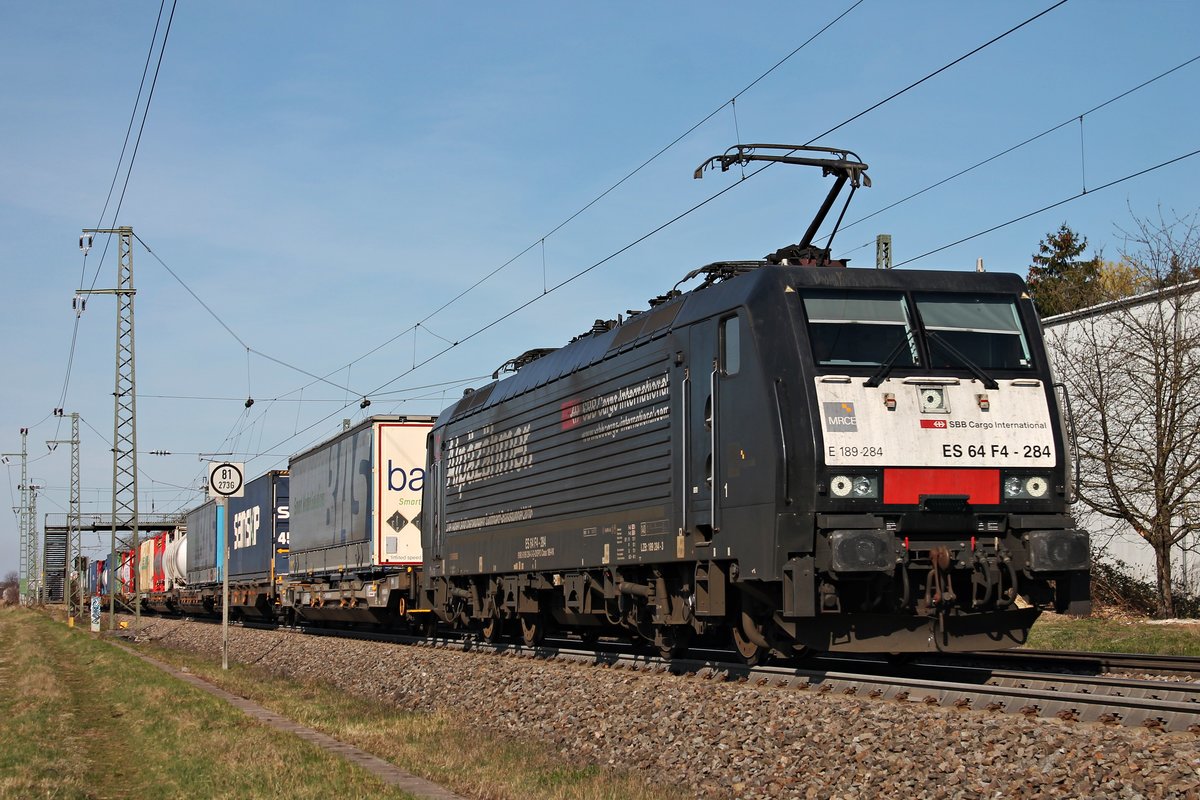 Mit einem Containerzug aus Rotterdam fuhr am Nachmittag des 20.03.2019 die MRCE/SBBCI ES 64 F4-284 (189 284-3)  Alpäzähmer  durch den Haltepunkt von Auggen über die Rheintalbahn in Richtung Schweizer Grenze.