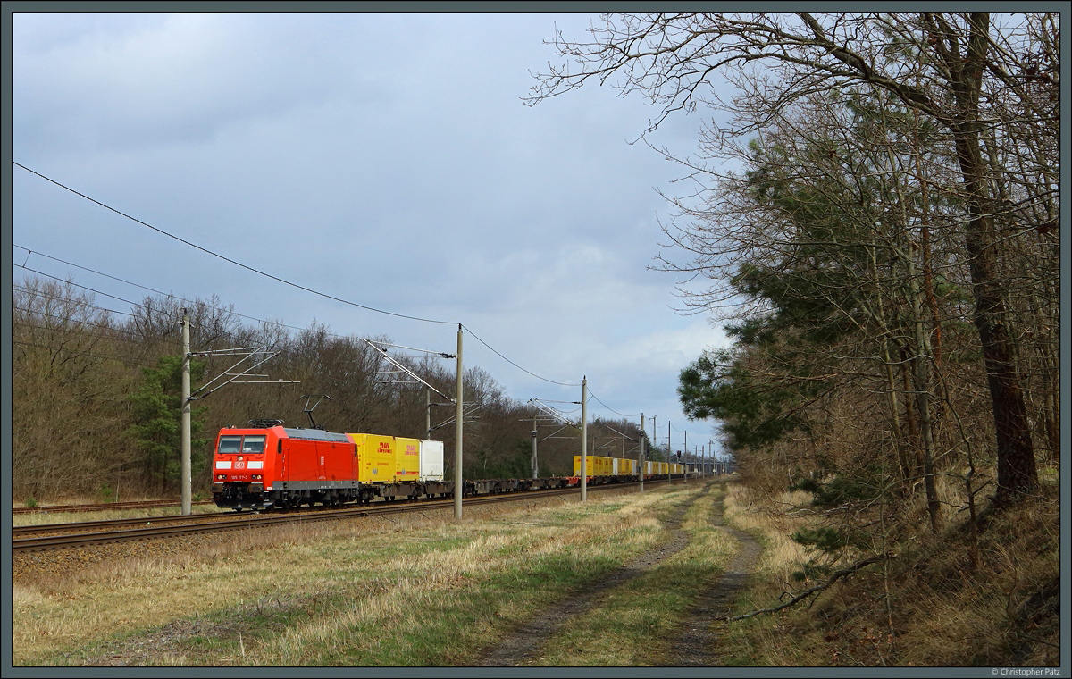 Mit einem DHL-Containerzug fährt 185 177-3 der DB Cargo am 10.04.2022 durch Burgkemnitz.