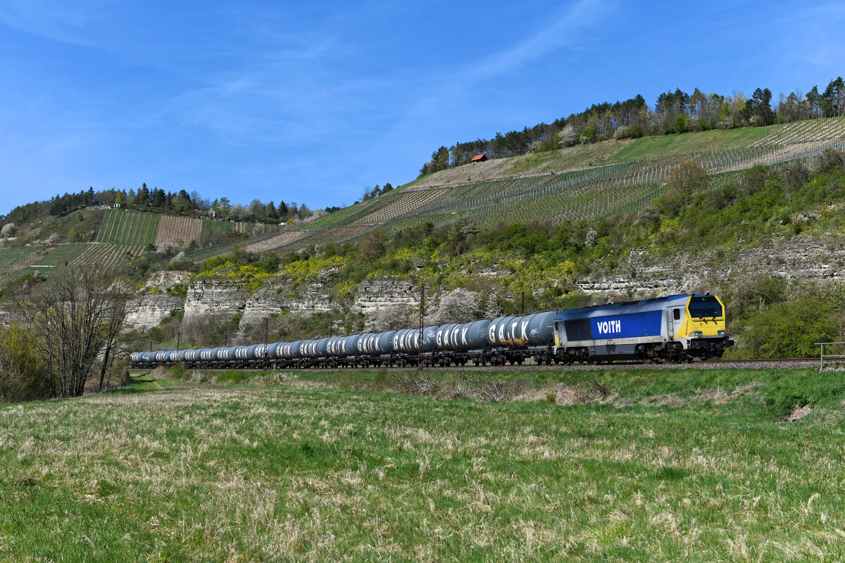 Mit einem einheitlich aus GATX-Kesselwagen bestehenden Zug war die 264 001 von Stock am 18. April 2022 bei Himmelstadt südwärts unterwegs. 