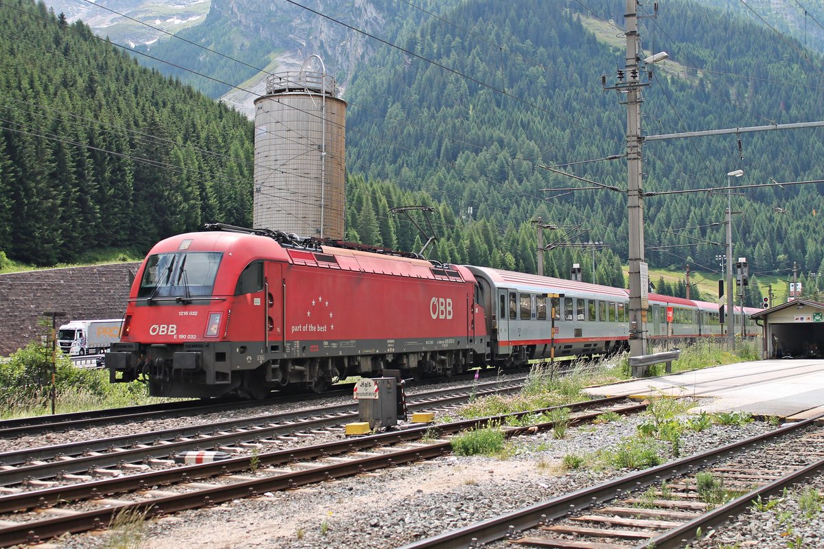 Mit einem EuroCity nach Rosenheim fuhr am Vormittag des 04.07.2018 die 1216 032 (E 190 032/ex. 1216 232) aus dem Bahnhof von Brenner, am RoLa-Terminal Brennersee vorbei, in Richtung Inntal.