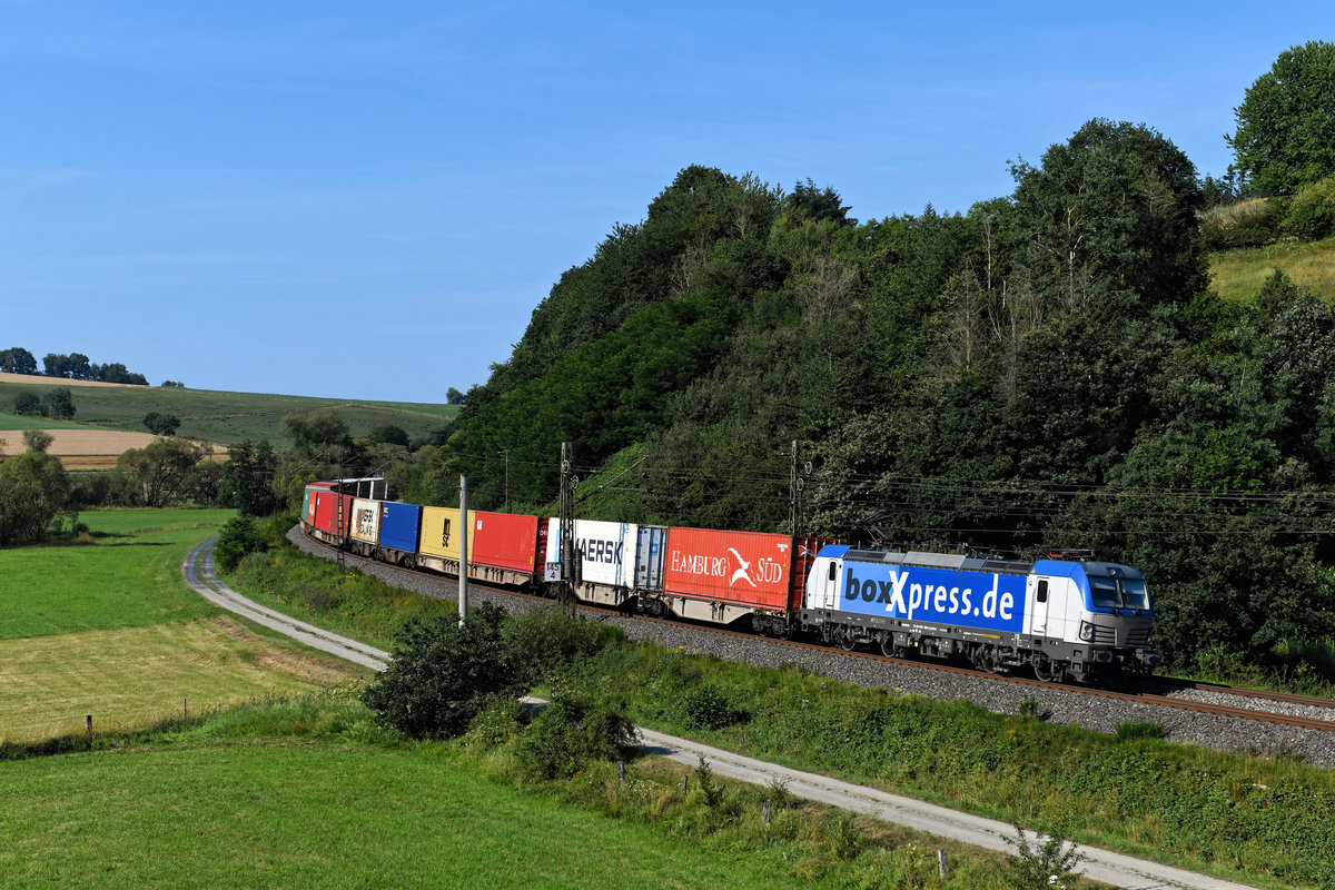 Mit einem farbenfrohen Containerzug war am 18. Juli 2020 die 193 883 von BoxXpress auf der Nord-Süd-Strecke unterwegs. Genauer gesagt mit dem DGS 69272 von München Riem nach Dradenau. Bei Hermannspiegel im Haunetal gelang die Aufnahme.