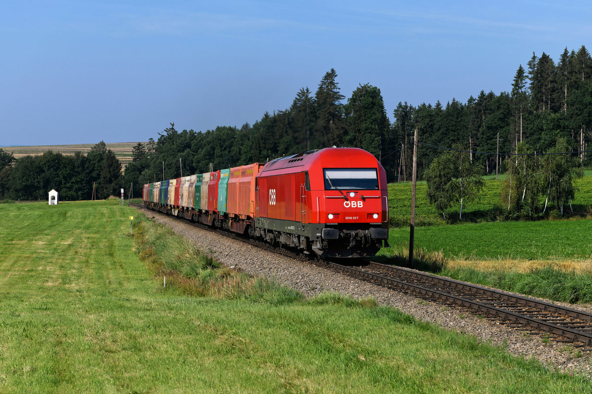 Mit einem Ganzzug beladen mit Hackschnitzeln war die 2016.027 am Morgen des 10. August 2020 von Waldhausen nach Schwarzenau unterwegs. Bei Gerotten galt es, eine ordentliche Steigung mit dem Zug zu überwinden. 
