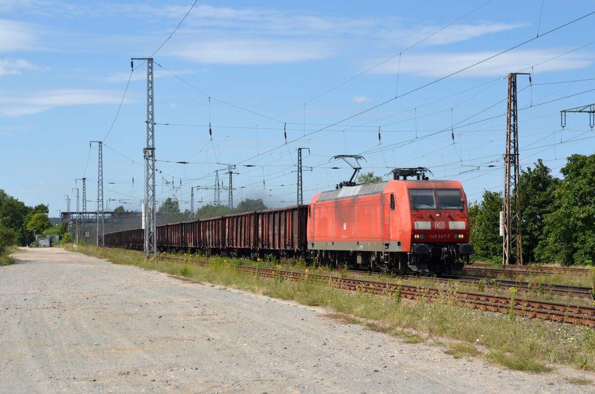 Mit einem Ganzzug Hochbordwagen und einer leichten  Rauchnote  rollt 145 047 am 14.08.21 durch Saarmund Richtung Schönefeld.