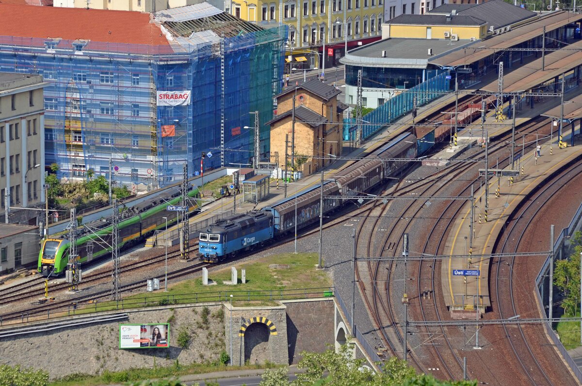 Mit einem gemischten Güterzug passiert 130 032 am 27.05.23 auf dem Weg Richtung Usti nad Labem zapad den Hauptbahnhof von Usti nad Labem. Dahinter erreicht der IC 16539 gerade sein Ziel. Fotografiert von der Vetruse aus.