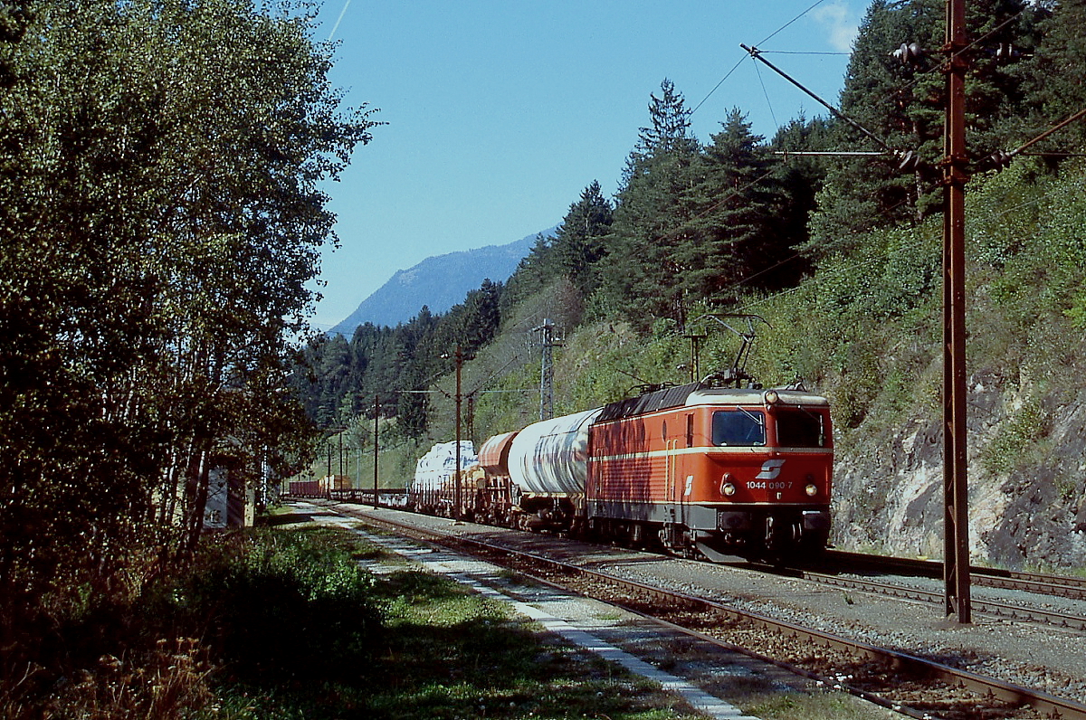 Mit einem Güterzug durchfährt 1044 090-7 im September 2003 den Bahnhof Mühldorf-Möllbrücke. Kurz danach wurden die noch aus der Zeit der Elektrifizierung stammenden Oberletungsmasten durch neue ersetzt.