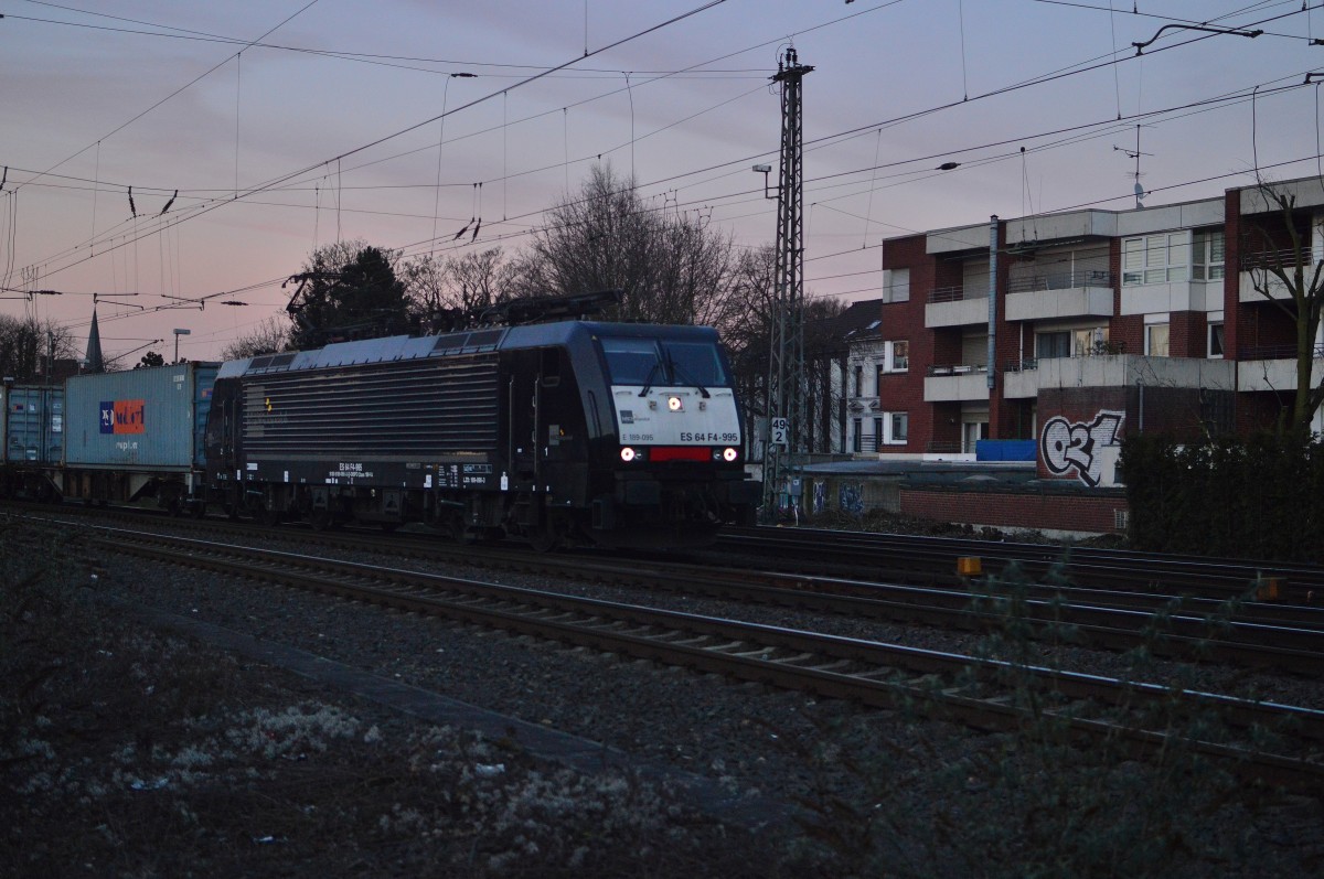 Mit einem Kastelzug am Haken ist die ES 64 F4 995 durch Rheydt Hbf fahrend in Richtung Köln unterwegs. 28.1.2016