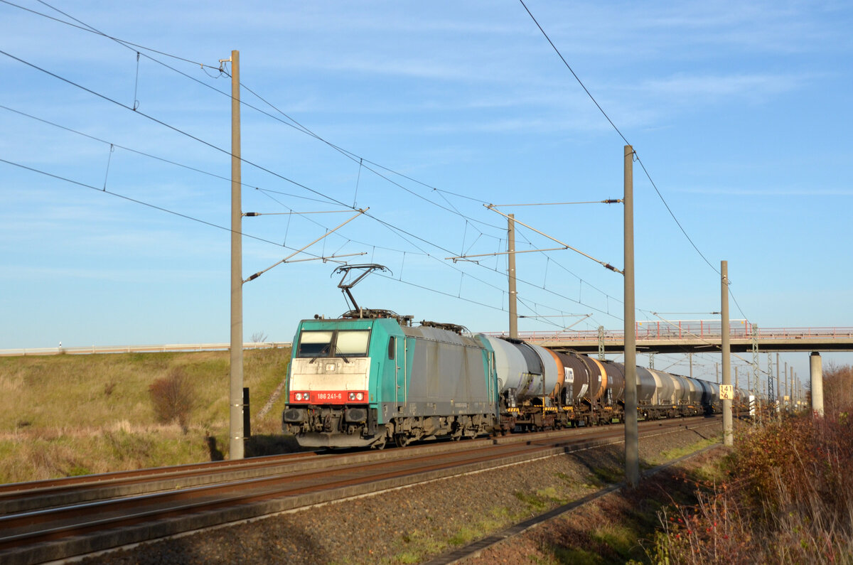 Mit einem Kessel- und Silozug von Transchem am Haken rollt 186 241 der Angel Trains am 27.11.22 durch Brehna Richtung Halle(S).
