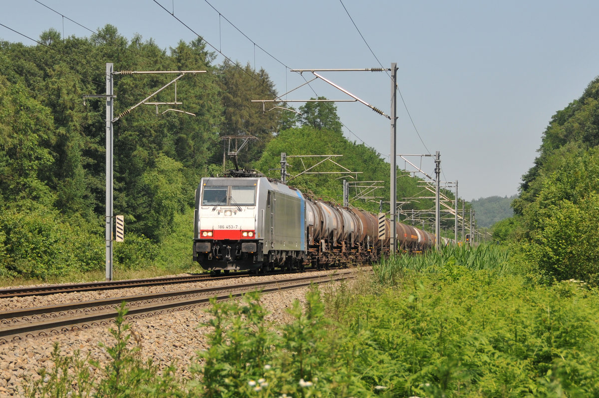 Mit einem Kesselwagenzug am Haken kommt die 186 453-7 von Lineas/Railpool von Aachen-West gen Montzen. Aufgenommen am 06/06/2018 im Gemmenicher Wald bei Moresnet-Chapelle.