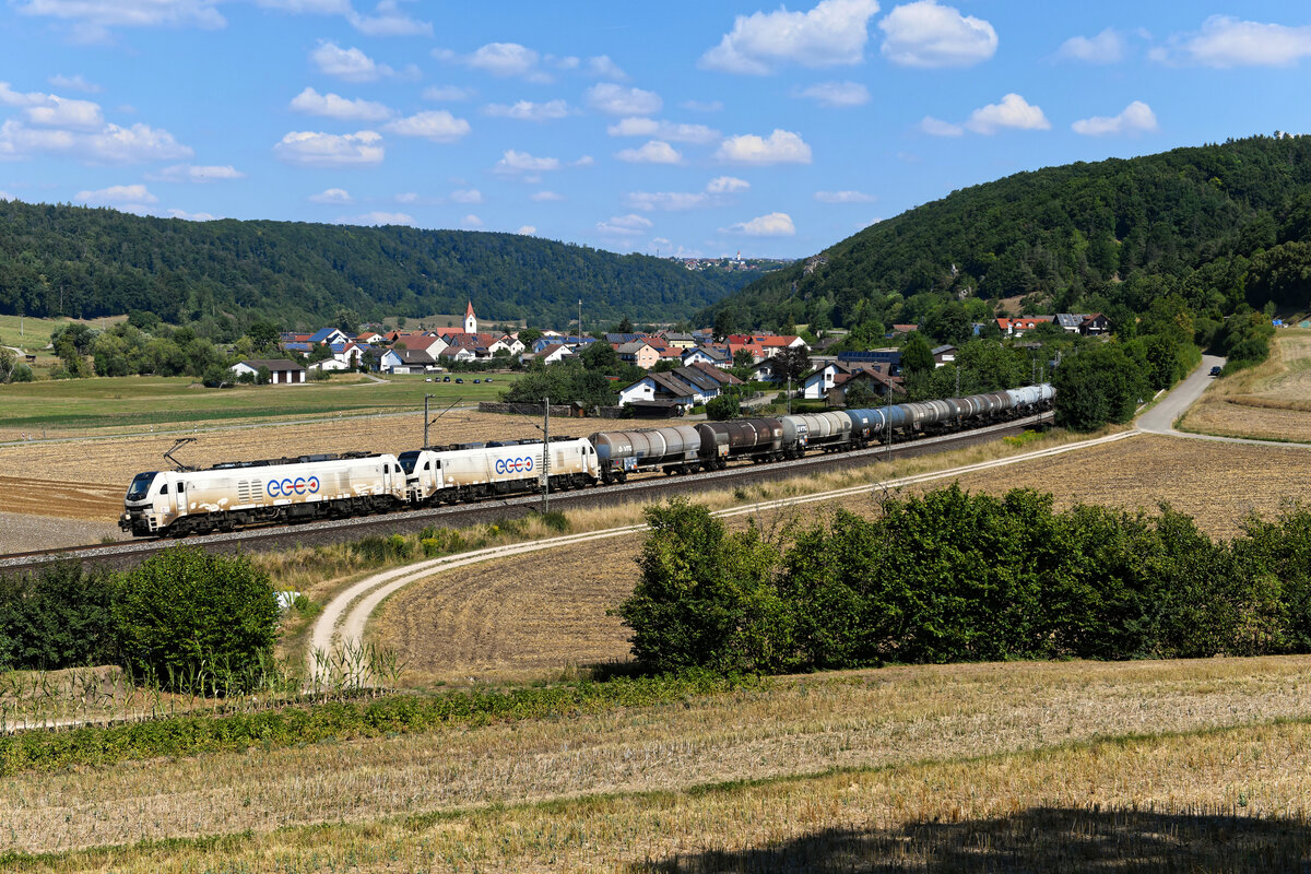 Mit einem Kesselwagenzug waren am 14. August 2022 die für Ecco Rail fahrenden 159 218 und 214 unterwegs. Das Tandem aus den beeindruckenden EURO DUAL Maschinen zeigte sich leider wenig fotogen, da ihnen das einsetzende EVU viel zu selten eine Wäsche gönnt. Bei Breitenfurt betätigte ich dennoch erfreut den Auslöser meiner Kamera, allzu oft sieht man nämlich nicht gleich zwei Exemplare dieser starken Zweikraftlokomotiven vor einem Zug. Zum Laufweg der Leistung ist mir leider nichts bekannt. 