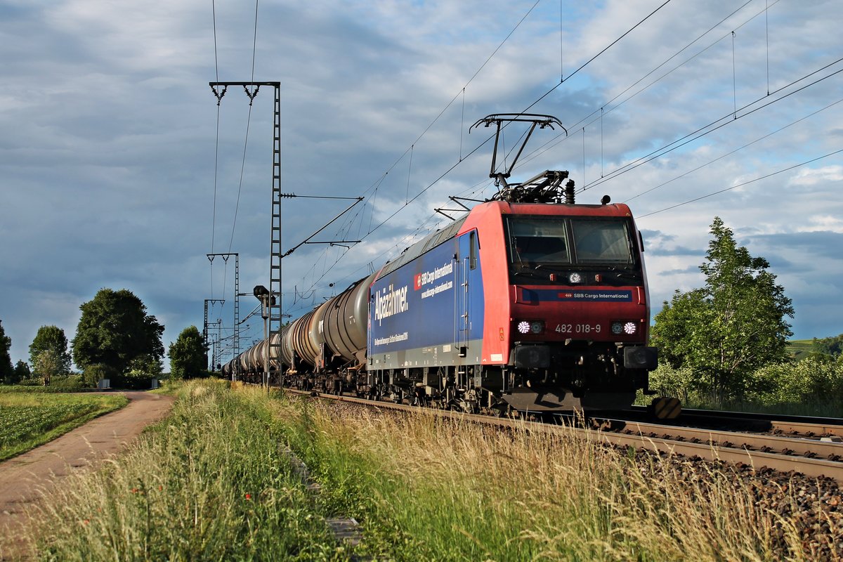 Mit einem Kesselzug fuhr am 06.06.2017 die Re 482 018-9  Alpäzähmer  nördlich von Müllheim (Baden) durchs Rheiuntal in Richutng Schweizer Grenze.