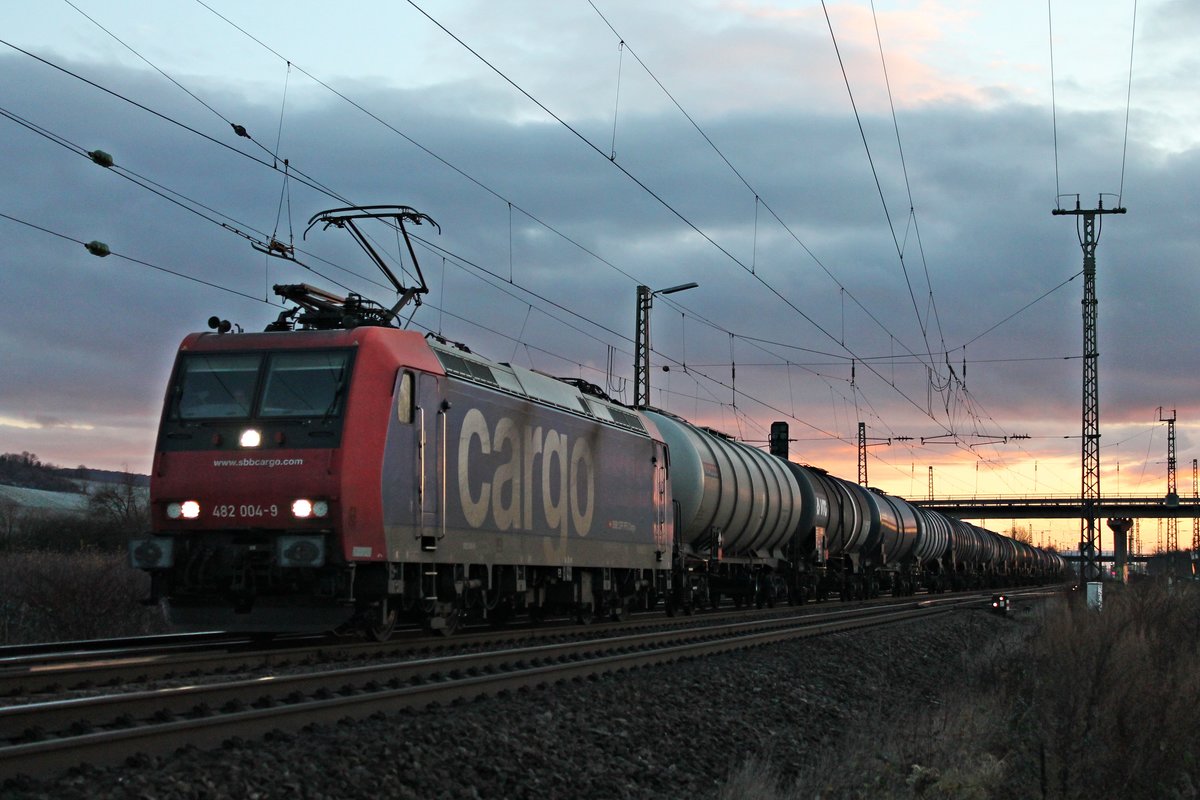 Mit einem leeren Kesselzug aus Glattburg (CH) und Fernlicht fuhr am Nachmittag des 09.12.2017 die Re 482 004-9 durch die Überholgleise in Müllheim (Baden) in Richtung Freiburg (Breisgau).