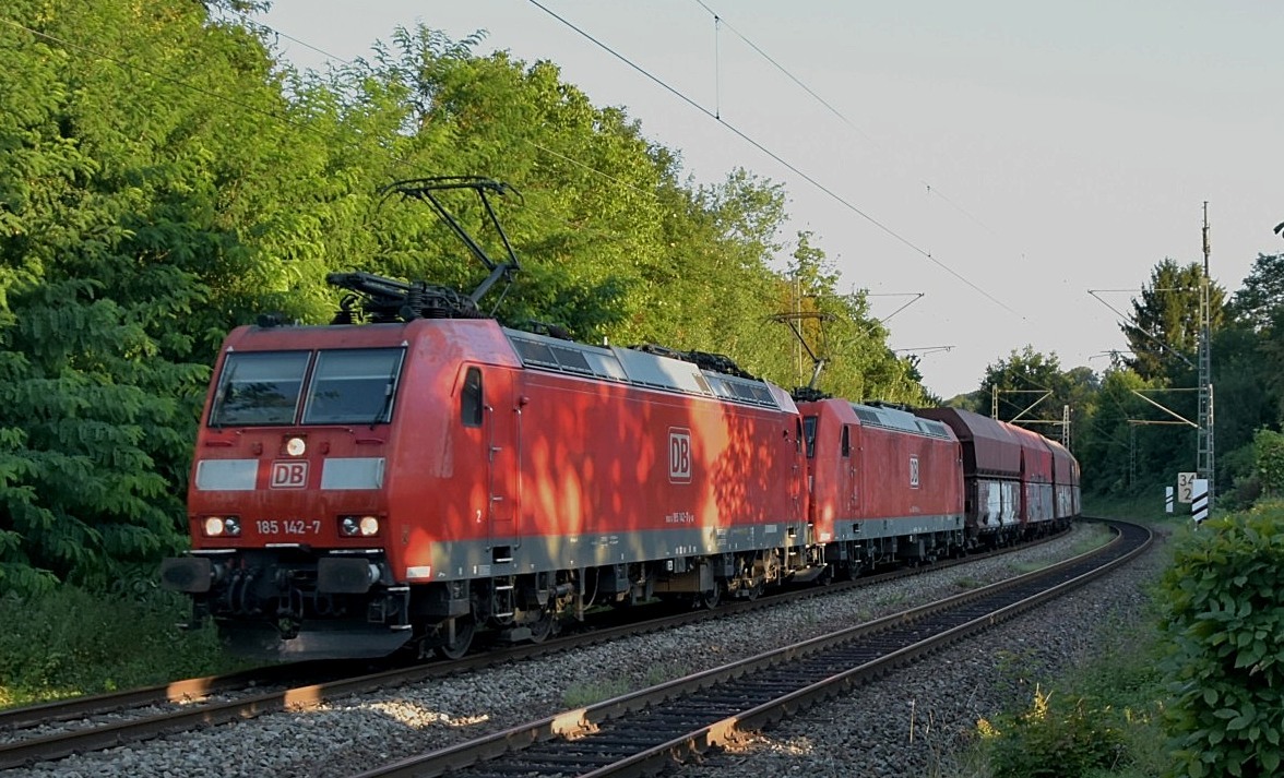 Mit einem leeren Kohlewagenzug kommt die 185 142-7 samt der 185 018-9 am Abend des 5.8.2020 durch Neckargerach gen Heidelberg gefahren.