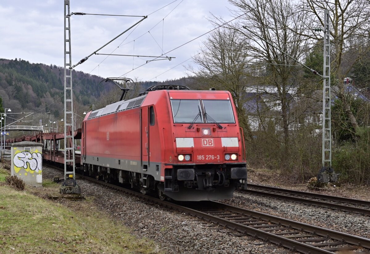Mit einem Leerzug Autotransportwagen kommt die 185 276 am Mittag des 24.2.2022 durch Neckargerach  gen Bad Friedrichshall Hbf  gefahren.