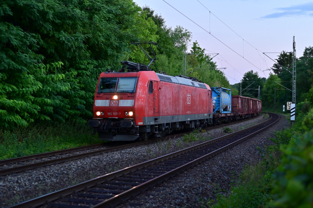 Mit einem Mischer am Haken ist die 185 137-7 auf der Neckartalbahn gen Heidelberg fahren zusehen, hier ist sie in Neckargerach am Freitagabend den 12.August2022. LG an den TF, ich hoffe das ich nicht ein zuschlechtes Bild abgegeben habe, habe leider erst zuhause bemerkt das ich auch aufgenommen wurde.....hätte ich es gewusst, hätte ich natürlich meinen Sonntagsanzug angehabt.;-)))