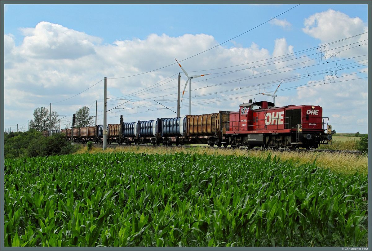 Mit einem Müllzug rollt 160074 der OHE Cargo am 10.07.2015 bei Wellen Richtung Magdeburg. 