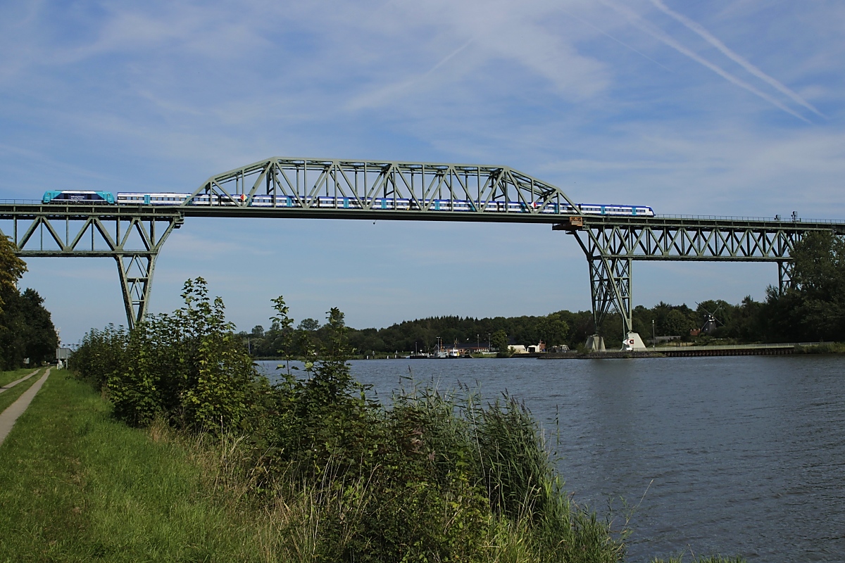 Mit einem RE von Hamburg-Altona nach Westerland überquert eine 245 am 23.08.2019 auf der Hochbrücke in Hochdonn den Nord-Ostsee-Kanal. Auf der Brücke herrschte übrigens wesentlich mehr Verkehr als auf dem Kanal (sieht man mal von einigen Segelbooten mal ab).
