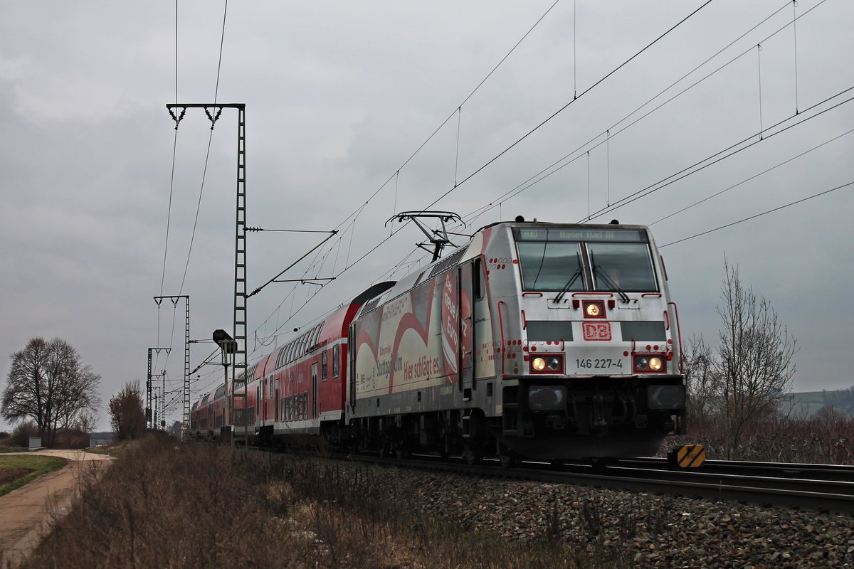 Mit einem RE (Offenburg - Basel Bad Bf) fuhr am 19.02.2018 die Freiburger 146 227-4  Bahnprojekt Stuttgart-Ulm  nördlich von Müllheim (Baden) in Richtung des dortigen Bahnsteiges, um dort ihren nächsten Zwischenhalt einzulegen.