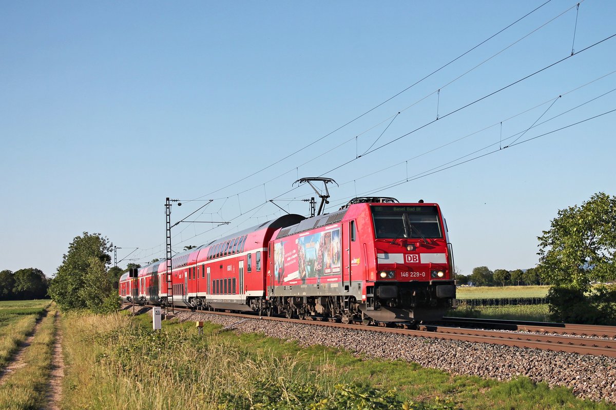 Mit einem RE (Offenburg - Basel Bad Bf) fuhr am Abend des 13.06.2019 die Freiburger 146 229-0  Europa Park  südlich von Buggingen über die Rheintalbahn in Richtung Müllheim (Baden).