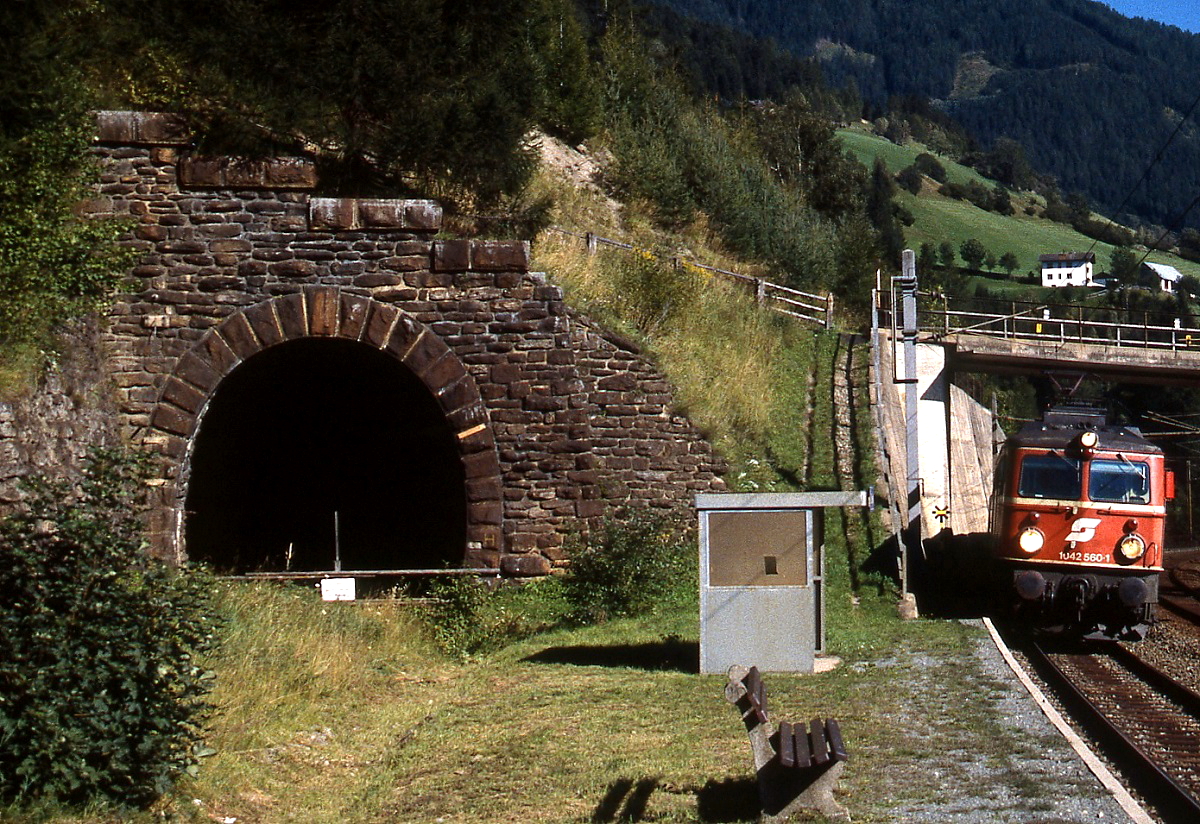 Mit einem Regionalzug trifft 1042 560-1 um 2000 in Oberfalkenstein ein. Daneben das Tunnelportal der  alten  Tauernbahn.