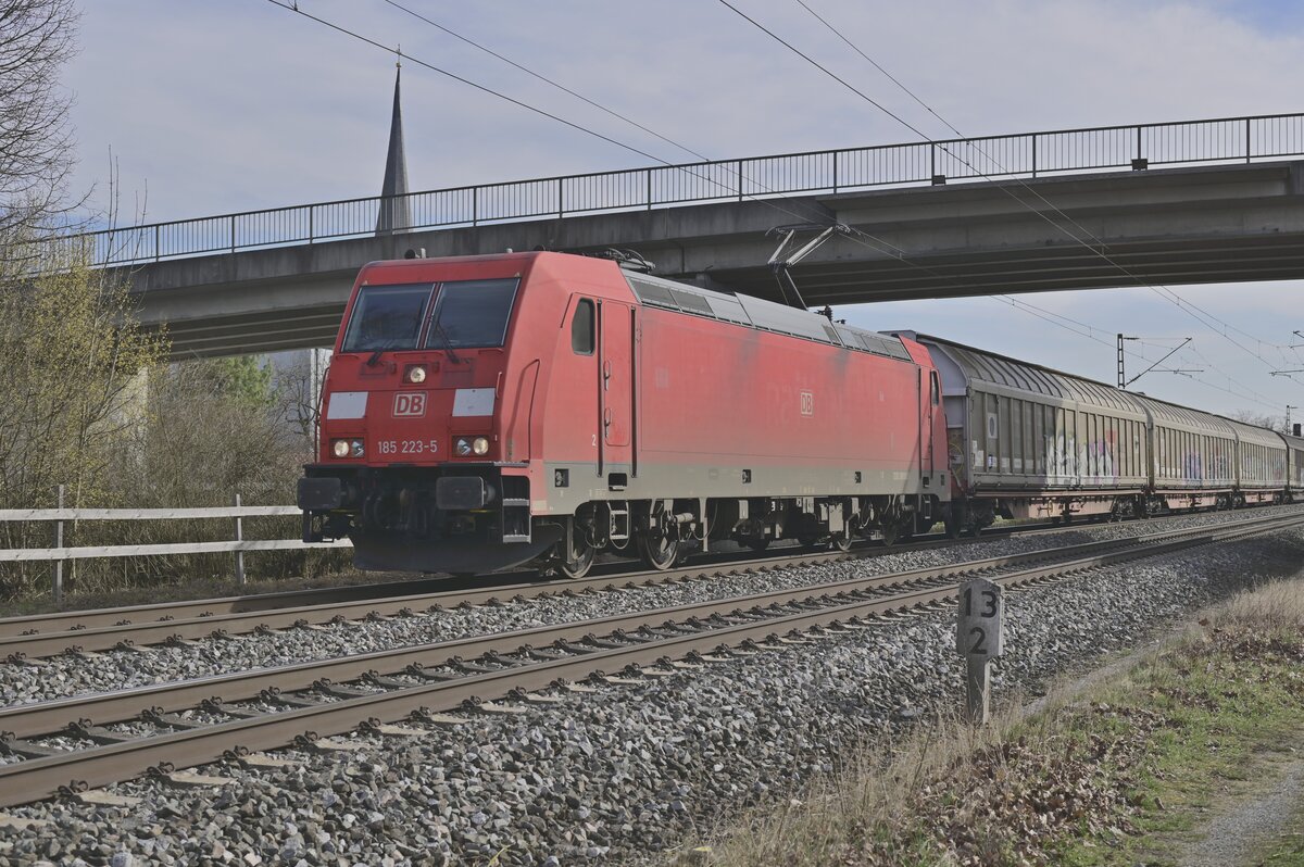 Mit einem Schiebewandwagenzug durch Thüngersheim ist DBC 185 223 zusehen am 1.3.2022