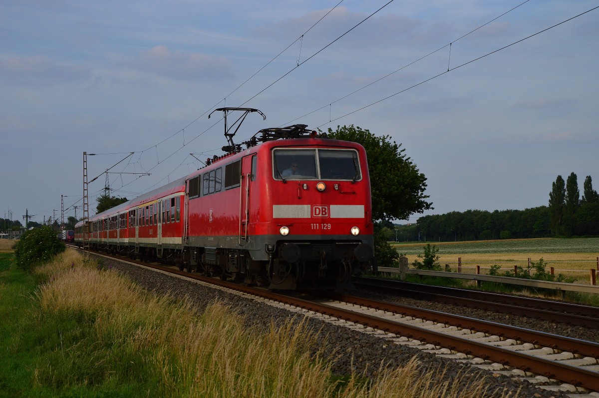 Mit einem Verstärkerzug auf der Linie RE4 kommt die 111 129 bei Wickrathhahn am Fotografen vorbei. 29.6.2015