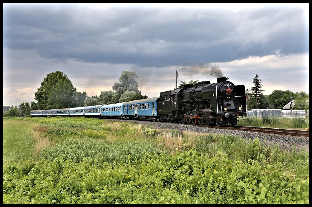 Mit einem voll besetzten Sonderzug von Tapolca nach Balatonfüred nähert sich hier am 16.7.2022 um 16.30 Uhr die MAV Dampflok 242 247 dem Haltepunkt Nemesgulacs Kisapati.