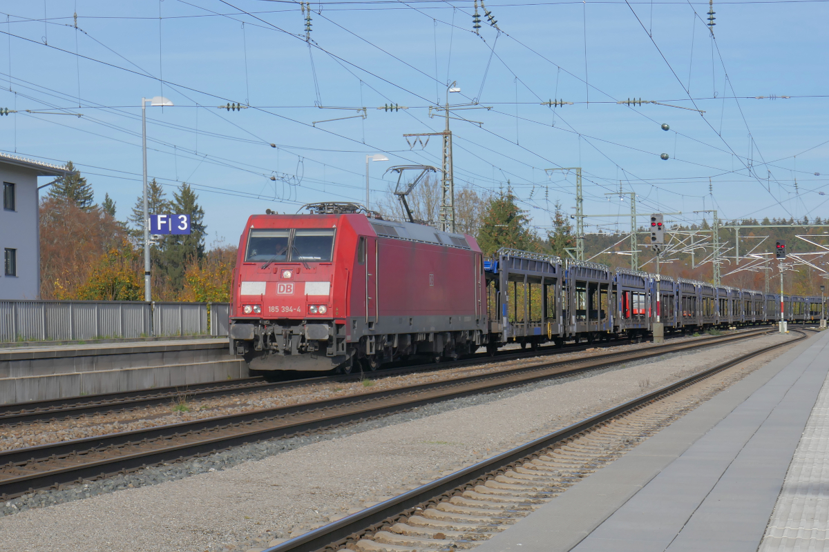 Mit einem Zug leerer Autotransportwaggons durchfährt die 185 394 den Bahnhof Traunstein in Richtung München. 
Donnerstag, 3. November 2022
