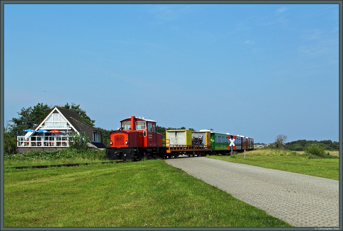 Mit einem Zug zum Anleger Langeoog passiert Lok 3 am 21.08.2015 die Golfstuben. Die Container auf dem ersten Wagen dienen dem Gepäcktransport. 