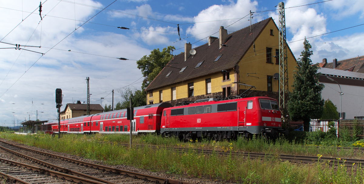 Mit Einführung des SÜWEX war auch die Zeit der BR 111 auf der Saarstrecke vorbei.
Der RE Mannheim - Trier wurde durch den SÜWEX Mannheim - Koblenz ersetzt. Dies hat aber nicht nur Vorteile, denn der alte RE hielt zwischen Saarbrücken und Trier auch an enigen Unterwegsstationen wie in Bous, Beckingen, Besseringen und Serrig, Halte, die der SÜWEX nicht mehr bedient. 111 115 schiebt den RE Mannheim - Trier und wird gleich im Bahnhof Bous halten. Bahnstrecke 3230 Saarbrücken - Karthaus am 04.07.2013