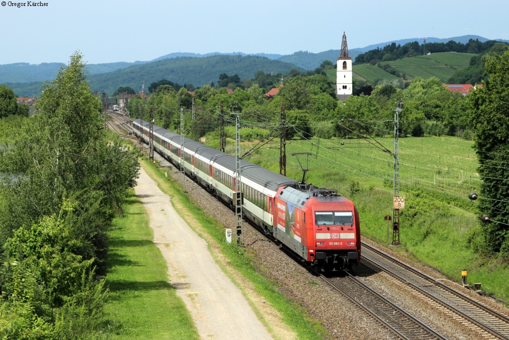 Mit etwa 50 Minuten Verspätung zieht die 101 092-5  swisstravelsystem.com - Bernina-Express abenteuerlich  den EC 9 Hamburg-Chur durch Denzlingen. Aufgenommen am 07.06.2014. Durch die Verspätung konnte der Zug an dieser Stelle in einem besseren Licht aufgenommen werden.