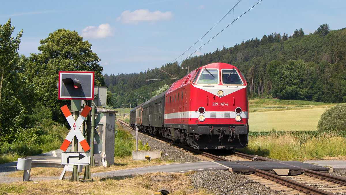 Mit ganz viel Sonne nähert sich der Sonderzug dem Bahnübergang bei Mönchröden. Zuglok war 229 147-4 und das Ziel war Sonneberg. War doch Tag der offenen Tür bei Piko. 