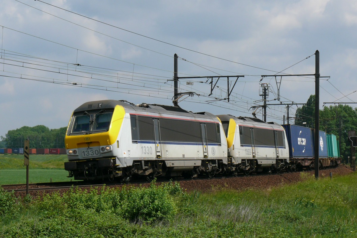 Mit gebündelter Kraft ziehen HLE 1330 und 1322 einen langen Containerzug über die Schleife bei Ekeren. Am linken Bildrand erkennt man noch das Zugende. Aufgenommen am 12/06/2010.