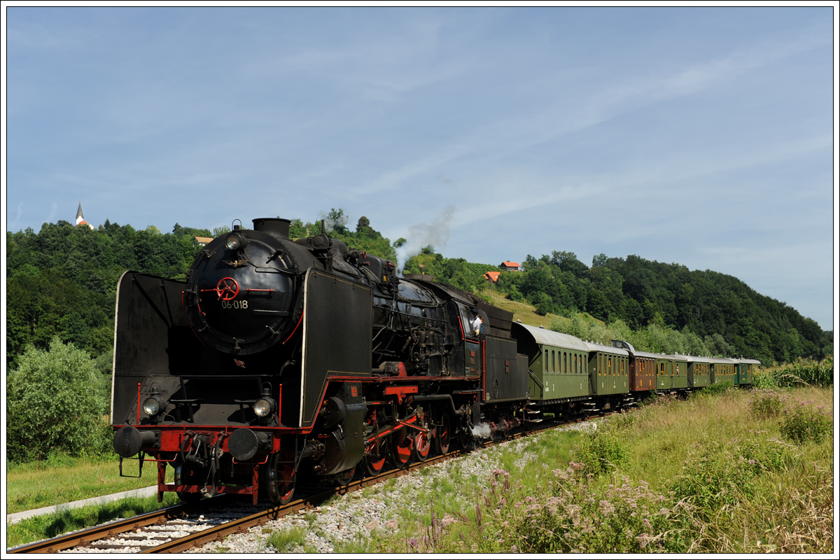 Mit geschlossenem Regler rollt 06-018 mit ihrem UEx 13420 von Celje nach Imeno am 1.8.2015 Richtung Haltestelle Sodna vas.

Infos zum Zug: http://www.slo-zeleznice.si/en/passengers/slovenia/on-an-excursion/Po_De%C5%BEeli_celjski