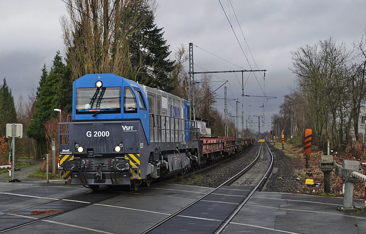 Mit ihrem asymmetrischen Führerhaus sieht die Vossloh G 2000 schon etwas ungewöhnlich aus, hier die Lok 1037 der Dortmunder Eisenbahn am 22.02.2022 in Bochum-Riemke (Angabe zum Fotostandpunkt: Hinter der Fußgängeerschranke)