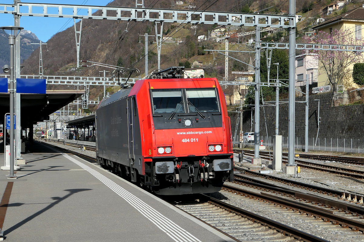 Mit ihrer Werbung  Gut für die Schiene - gut fürs Klima  rollt die 484 011 der SBB Cargo leer durch den Bahnhof Bellinzona gegen Süden, Richtung Giubiasco.
Bellinzona, 15. März 2023