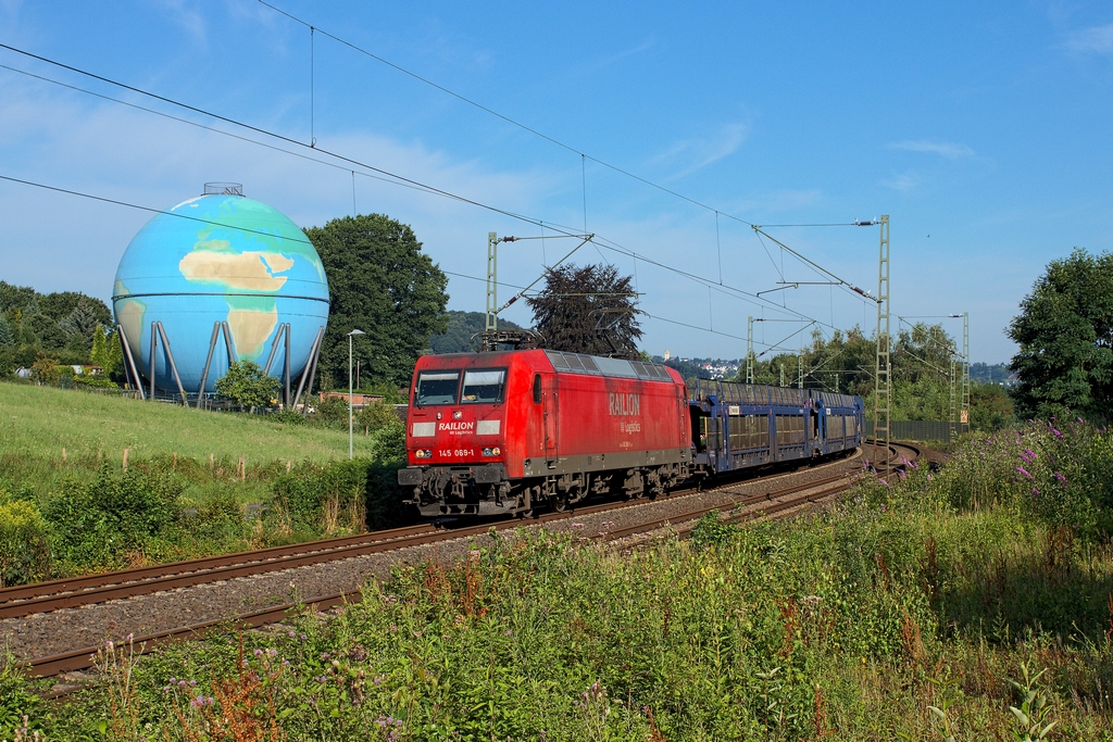 Mit leeren Autotransportwagen fuhr am 24.7.2014 die 145 069 Richtung Hagen, vorbei an dem ehemaligen Gasometer in Wengern, der 1997 als Weltkugel bemalt wurde