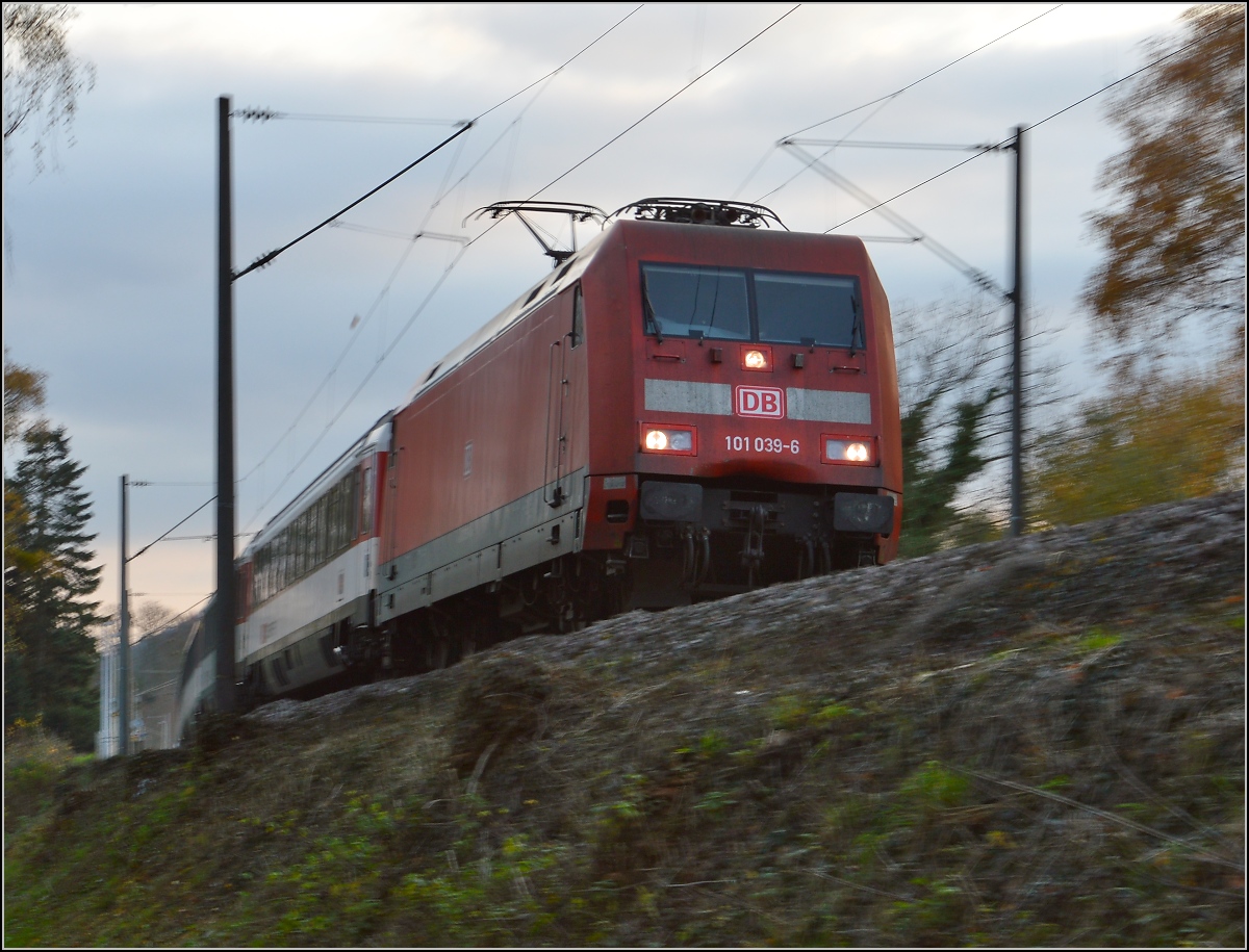 Mit leicht verbeultem Näschen zieht 101 039-0 in Singen am Fotografen eilig vorbei. November 2015.