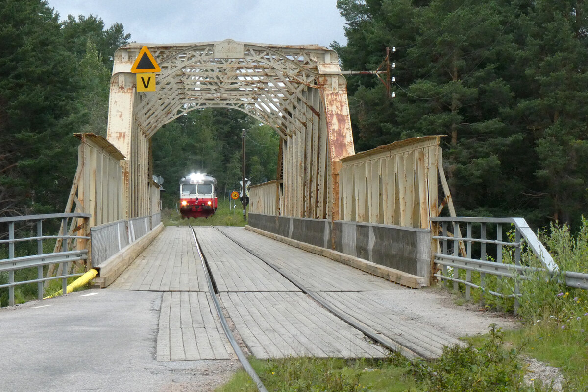 Mit leichter Verspätung erscheint der Triebwagen der Inlandsbanan auf der anderen Seite und hält an. Am folgenden Tag fahren wir im Führerstand mit und können das Prozedere vor dem Befahren der Brücke mitverfolgen. Sveg, 7.8.2024