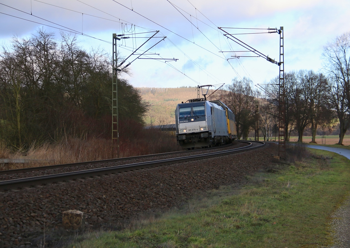 Mit Lichtgruß kommt 185 676-4 mit ihrem ARS-Autotransportzug Richtung Süden um die Ecke. Aufgenommen bei Niederhone am 12.02.2014.