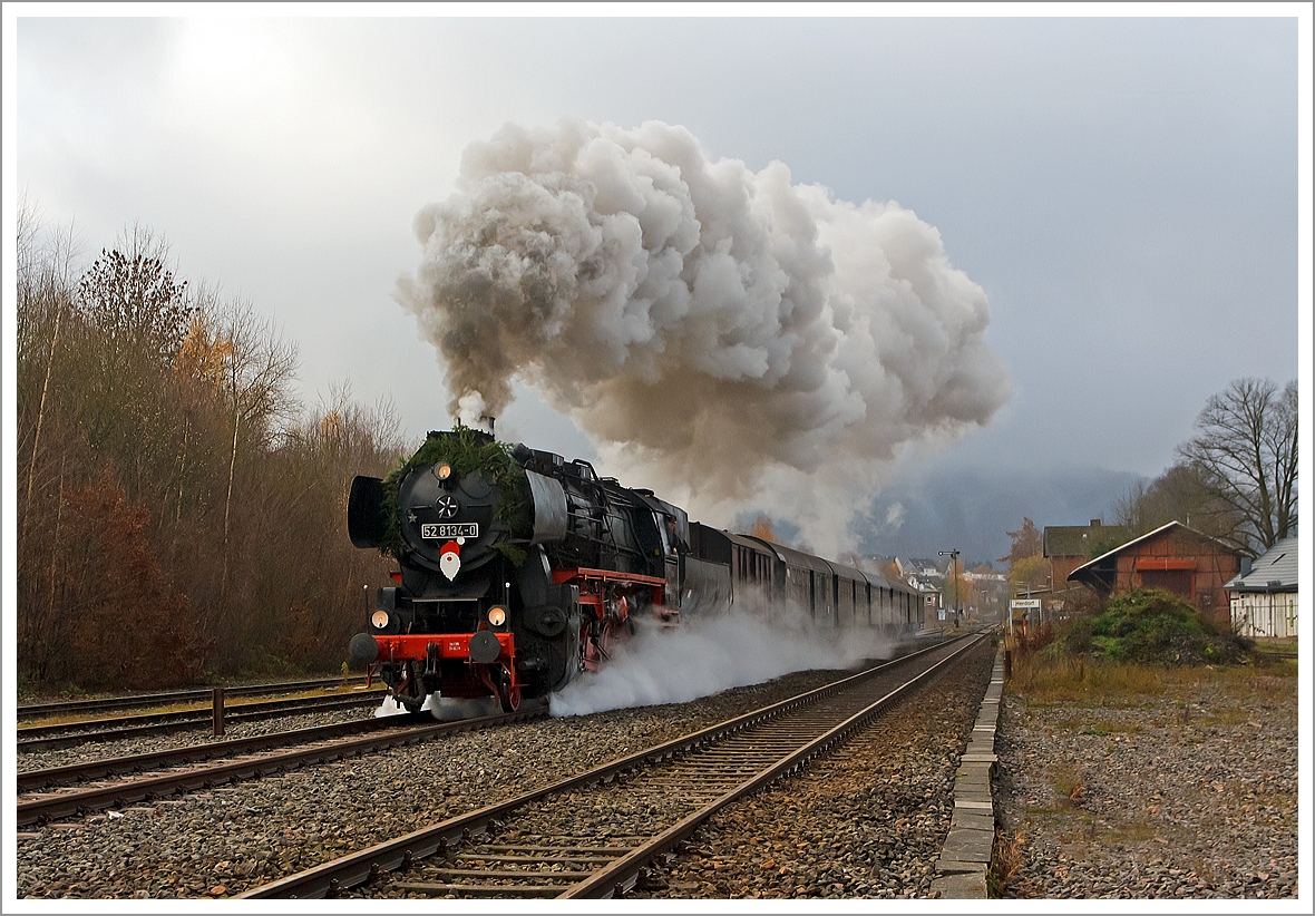 
Mit mächtiger Rauchfahne durchfährt die Betzdorfer 52 8134-0 am 01.12.2013 Herdorf, hier kurz hinter dem Bahnhof. Heute veranstalten die Eisenbahnfreunden Betzdorf ihre alljährlichen Nikolausfahrten zwischen Betzdorf/Sieg und Würgendorf.

Die Lok war, bedingt durch die Wiedervereinigung, eine der letzten Normalspurigen Dampfloks der DB.  Zudem war sie als 052 134-4 eine der wenigen wahren 52 der DB (BR 52.80). 

Die Lok wurde 1965 aus der 1943 bei der Lokfabrik Wien-Floridsdorf (Fabriknummer 16591) gebauten 52 7138 rekonstruiert. Diese hier ist auch nach als DB 052 134-4 gefahren. Sie wurde am 05.12.1994 z-gestellt und am 05.07.1995 bei der DBAG ausgemustert.

Eine freundlichen Gruß an den Heizer zurück, der sie tüchtig eingeheizt hat.