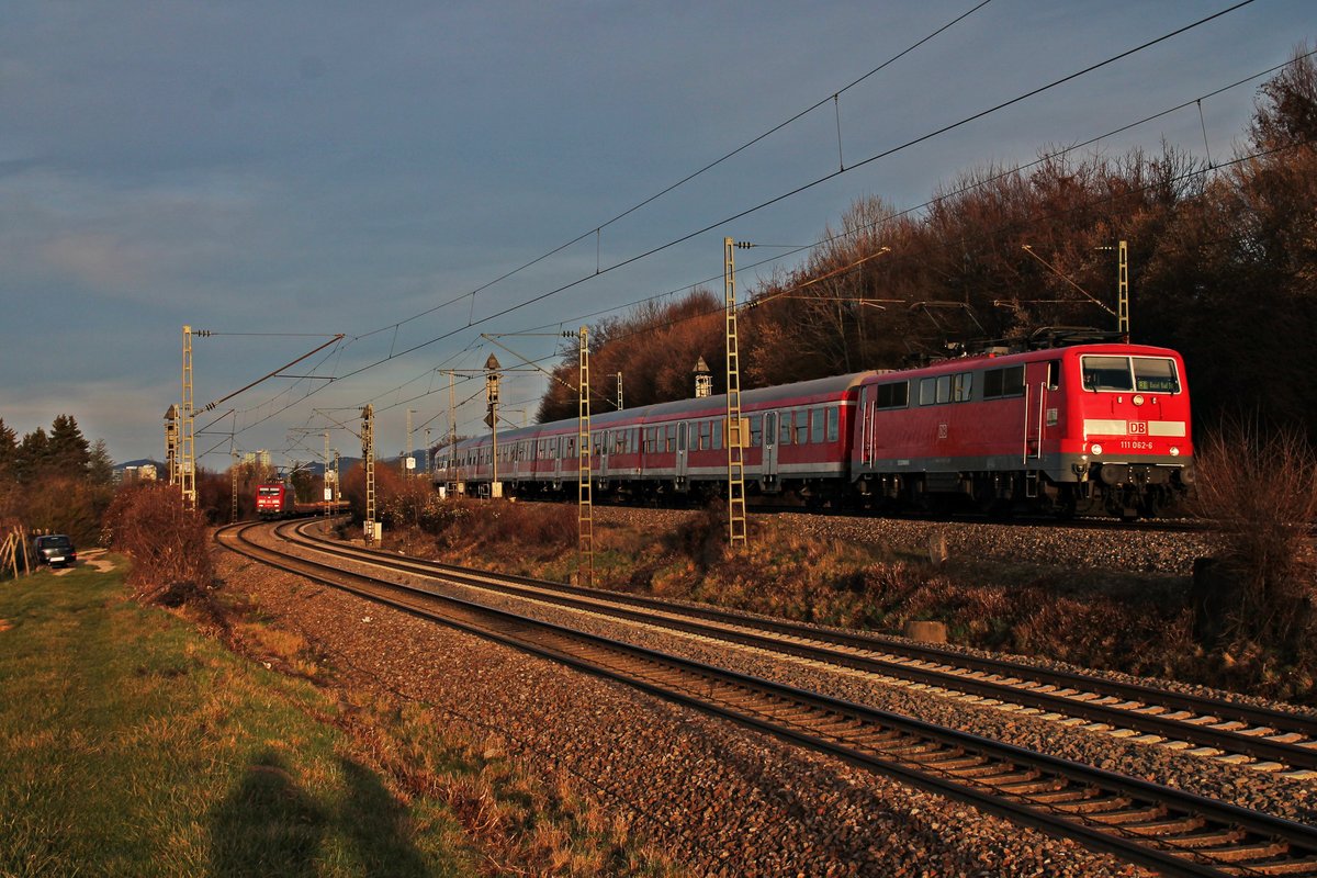 Mit einer RB (Offenburg - Basel Bad Bf) fuhr am 22.12.2015 die Freiburger 111 062-6  Neuenburg am Rhein  beim Abzweig Leutersberg in Richtung nächsten Zwischenhalt in Ebringen entgegen. Am linken Bild Rand wartete 145 013-9 mit einem leeren Fiatzug nach Alessandria aus Richtung Freiburg (Brsg) Rbf auf die Weiterfahrt nach Basel.
