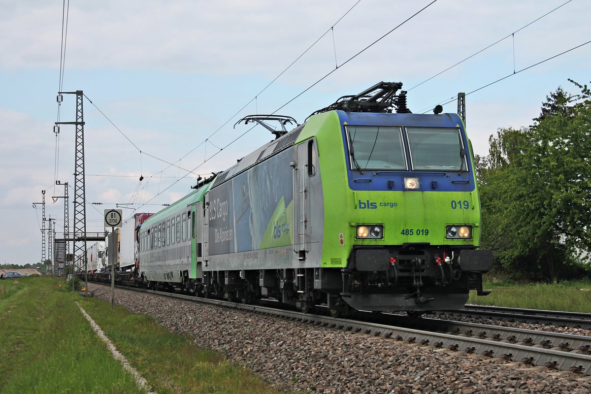 Mit einer RoLa (Freiburg (Brsg) Rbf - Novara Boschetto) fuhr am Nachmittag des 06.05.2019 die Re 485 019 durch den Haltepunkt von Auggen über die Rheintalbahn in Richtung Schweizer Grenze.