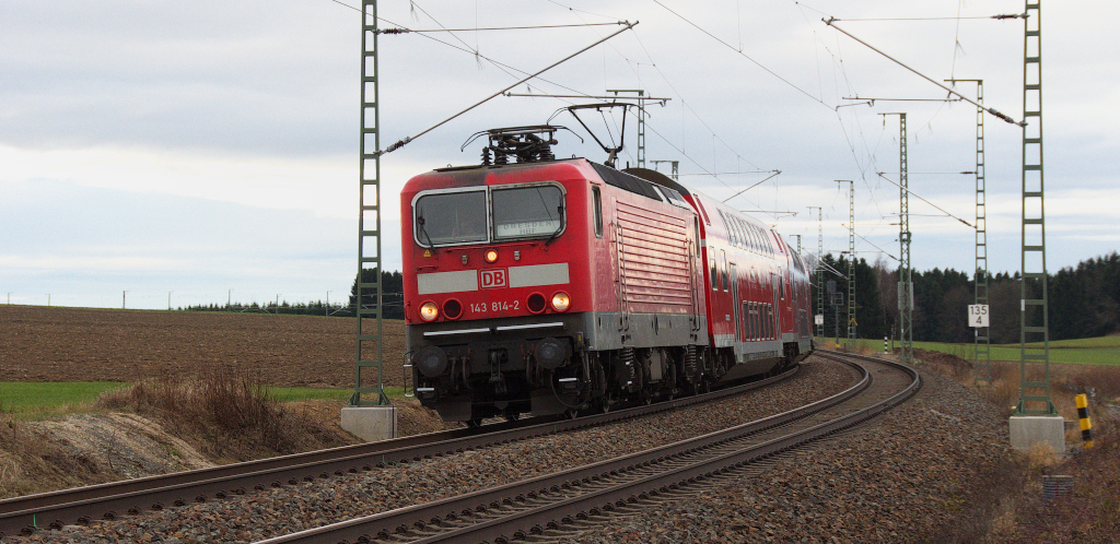 Mit Strom durch das Vogtland.....das war schon bei der DR bis nach Reichenbach oberer Bahnhof zu DDR Zeiten möglich.
Nun geht es unter Fahrdraht bis nach Hof, dort muß man nun umspannen oder umsteigen.
Alle zwei Stunden gibt es seit Fahrplanwechsel Dezember 2013 aber noch die RE Verbindung Dresden - Nürnberg. die mit 612er gefahren wird.
Die andere 612er Leistung wird nun als RE Dresden - Zwickau - Hof mit 143er und Dostos auch im Zweistundentakt gefahren.
Trotz Fahrdraht dieselt es ab er noch überwiegend im Vogtland, die Leistungen der Vogtlandbahn und der Erfurter Bahn werden mit Dieseltriebwagen erbracht.

143 814-2 zieht den RE aus Hof kommend in Richtung Plauen oberer Bahnhof hier bei Kornbach.
Danke an den Lokführer für den freundlichen Gruß.

Bahnstrecke 6362 Leipzig - Hof - 28.12.2013